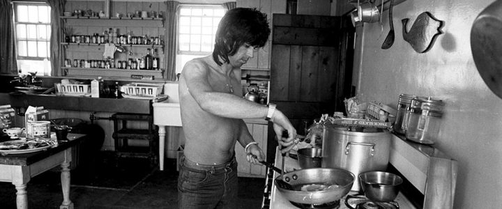 Keith cooking in the kitchen of Andy Warhol's Montauk home where the Rolling Stones were rehearsing for their 1975 Tour of the Americas. © Ken Regan, 1975