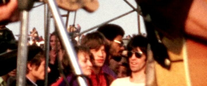 Mick Jagger (in red) and Keith Richards (in shades, natch), just off stage at the Altamont concert, hours before their segment turned deadly. Dec. 6, 1969. Home video footage. National Audio-Visual Conservation Center.